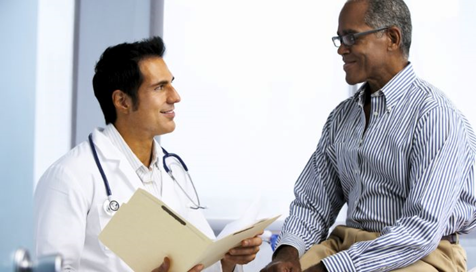 a male doctor talking to a male patient looking at files 